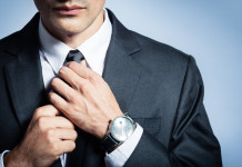 Man in a suit fixing his tie.