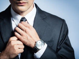 Man in a suit fixing his tie.