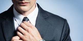 Man in a suit fixing his tie.